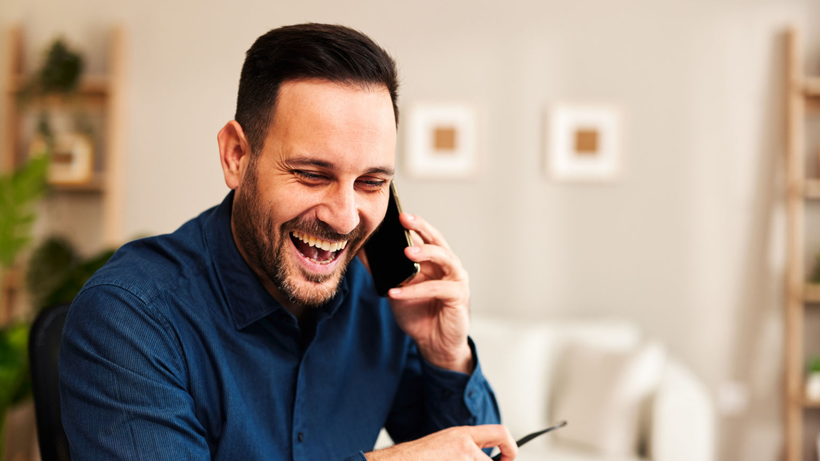 A customer laughs while on a phone call.