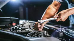 An automotive technician works on a car engine.