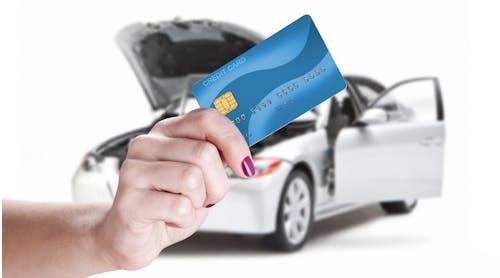 A woman pays for auto repair using a credit card.