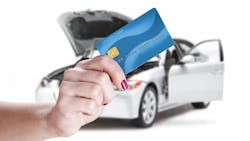 A woman pays for auto repair using a credit card. A woman pays for auto repair using a credit card.