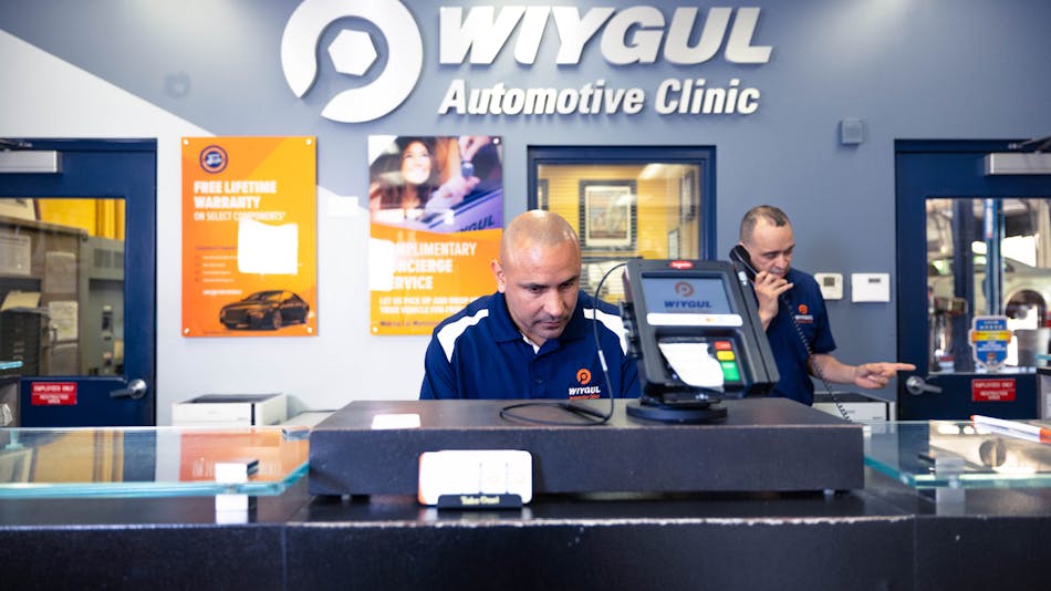 Team members at Wiygul Automotive Clinic with the new branding on the walls in the background.