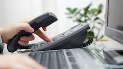 A service advisor prepares to make a phone call to a customer. A service advisor prepares to make a phone call to a customer.