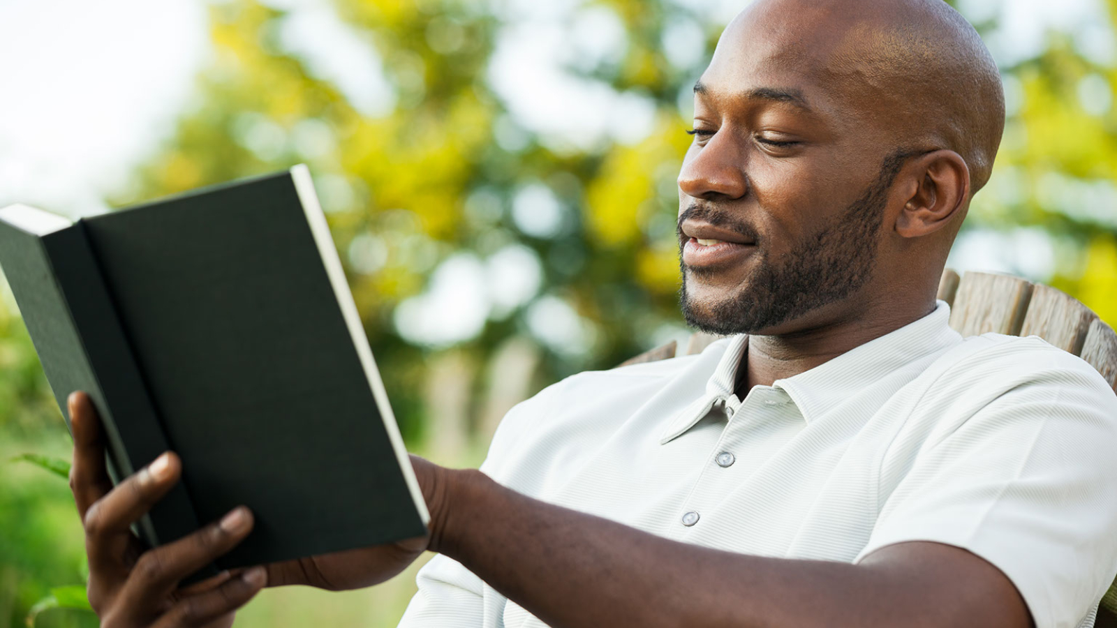 An auto repair shop owner reading a book.