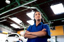 An auto repair shop owner stands confidently. An auto repair shop owner stands confidently.