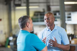 A service advisor talks with a shop owner. A service advisor talks with a shop owner.