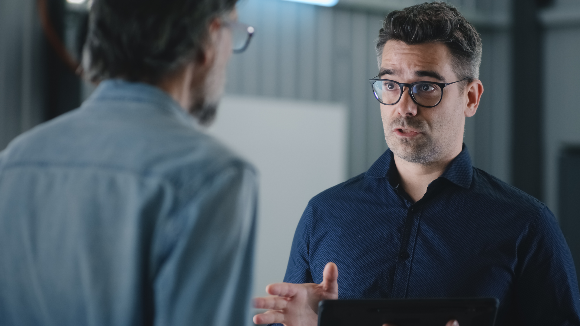 A shop owner talks to his service advisor.