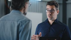 A shop owner talks to his service advisor. A shop owner talks to his service advisor.