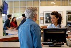 A service advisor speaks with a shop customer. A service advisor speaks with a shop customer.
