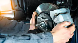 A technician working on a brake rotor.