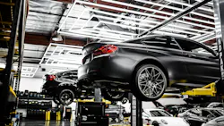 several vehicles on automotive lifts in a repair shop