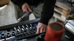 a mechanic reaching into a drawer of sockets