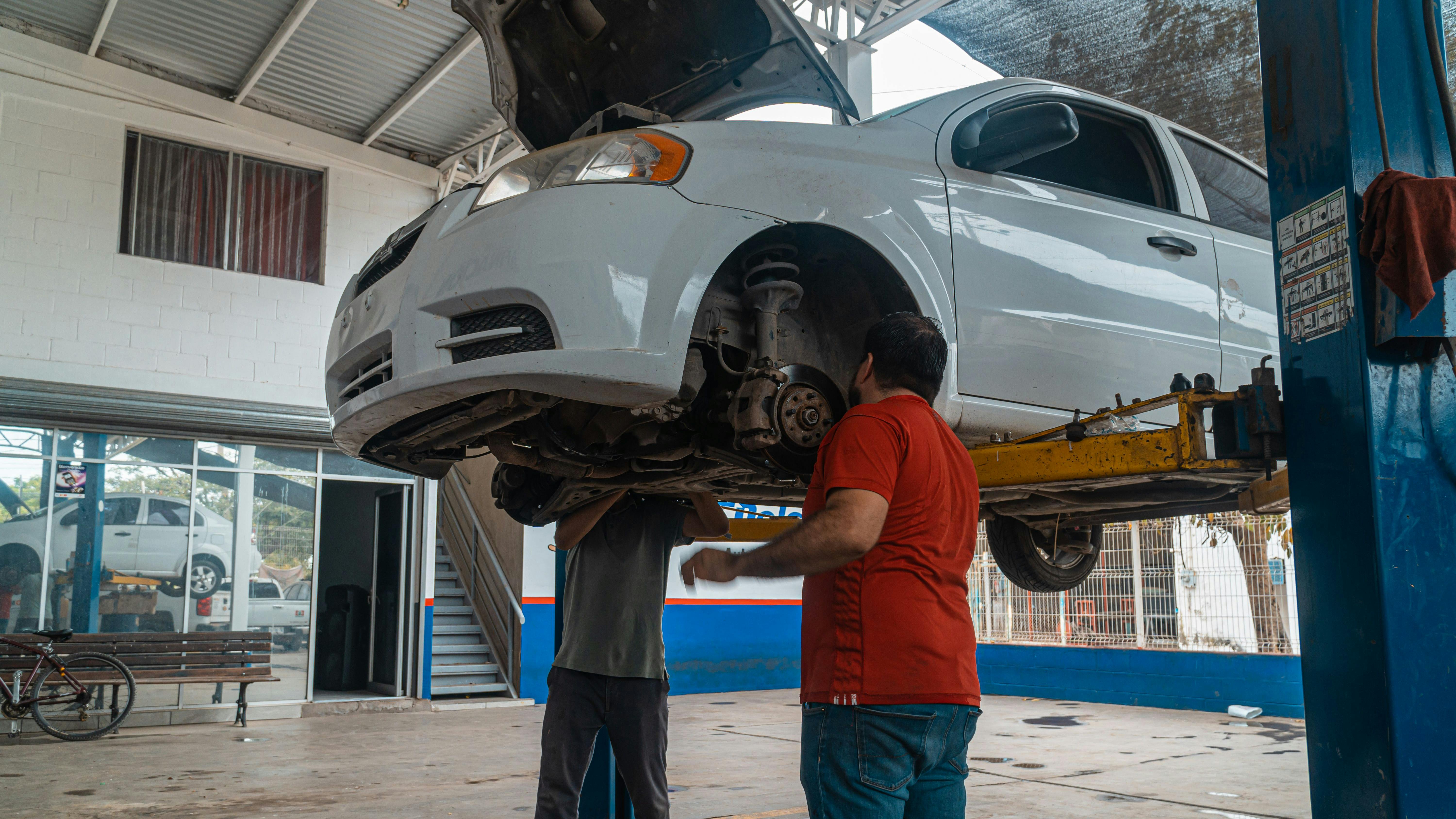 mechanics evaluate a vehicle on a lift